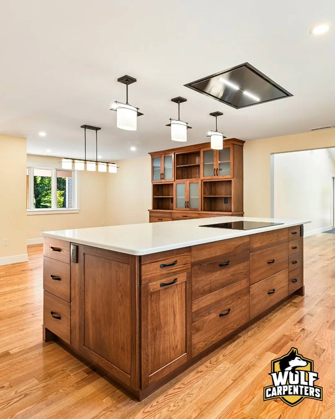 Kitchen island and custom built-in hutch with glass cabinets in a North Andover, MA kitchen