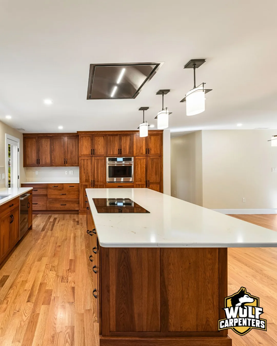 Custom kitchen island with white quartz countertop and pendant lighting in a North Andover, MA remodel