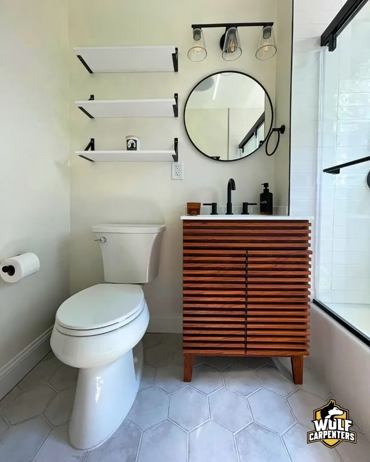 Modern bathroom remodel in Peabody, MA with a wood slat vanity, round mirror and hexagon floor tile